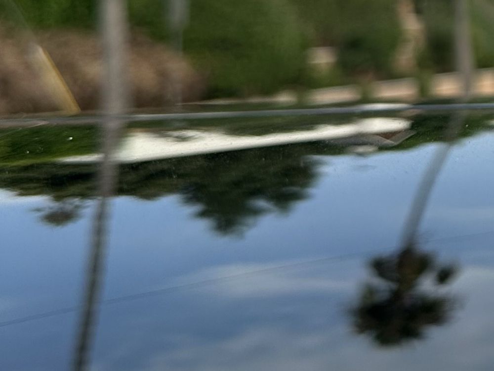 Glossy car paint reflecting the sky